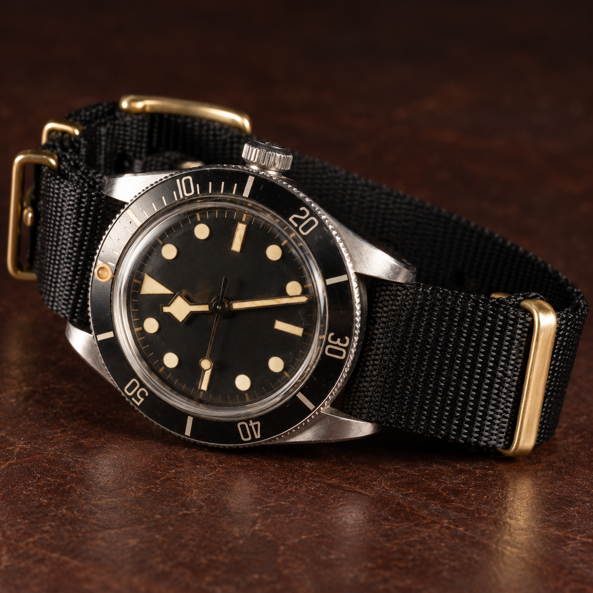 Black braided nylon strap with gold hardware on a vintage-style watch